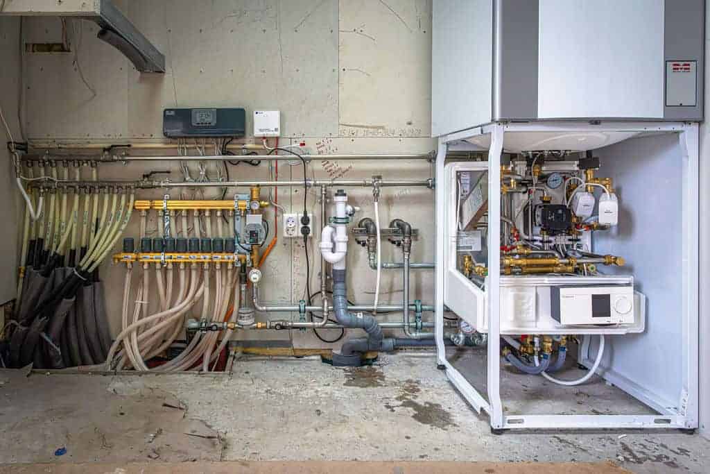 Professionelt opbygget teknikrum med varmeanlæg og rørledninger